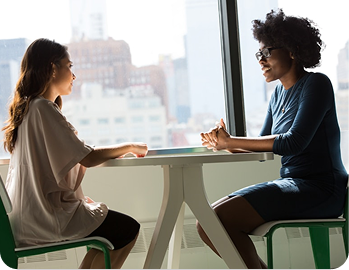 Two professionals meeting at a table in an office